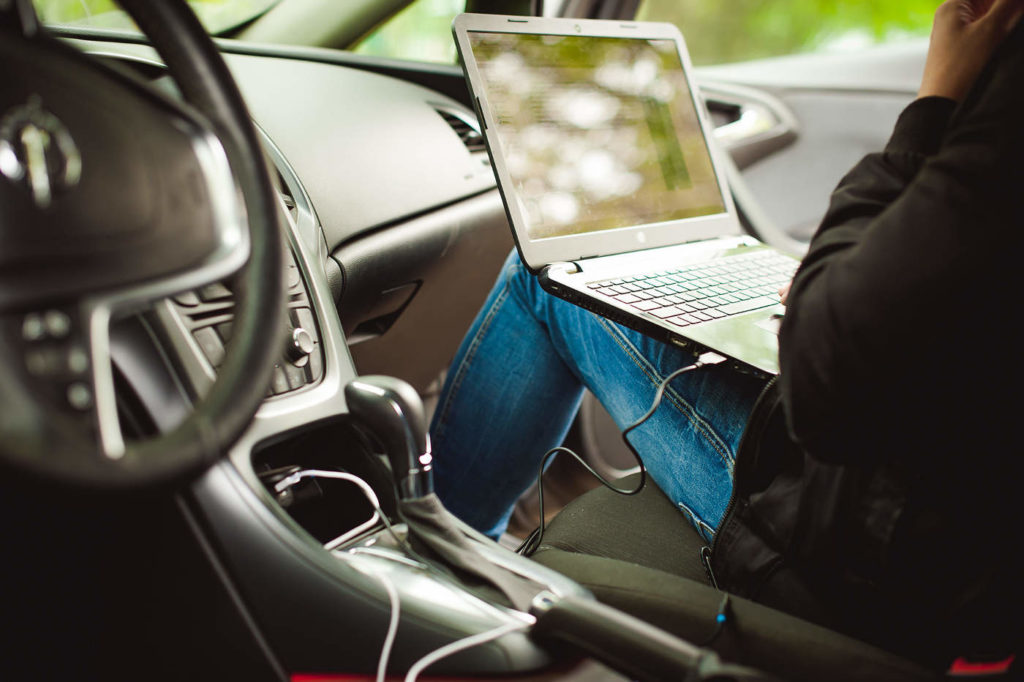 Foto Laptop auf dem Schoss im Auto - Arbeitsrecht Außendienst